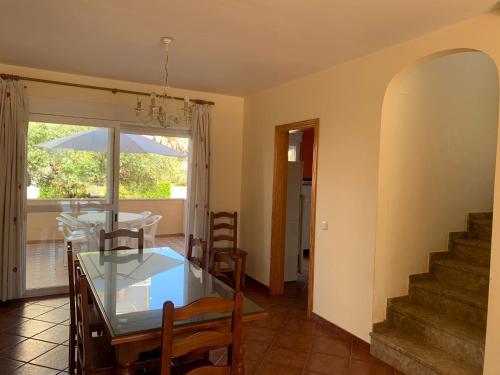 Un comedor con una mesa de cristal y sillas. en Casa KIKO, LA CASA ESTA EN LA ANTILLA 200METROS PLAYA, en La Antilla