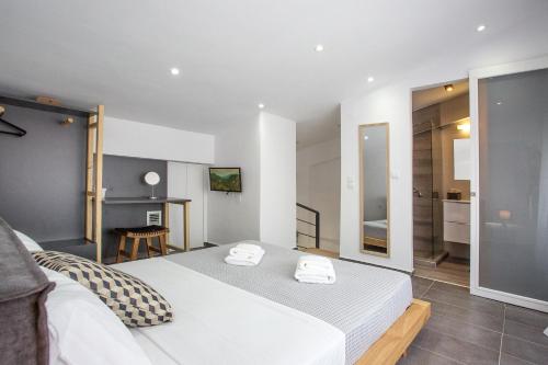 a bedroom with a bed with two towels at JOY C Deluxe in Iraklitsa