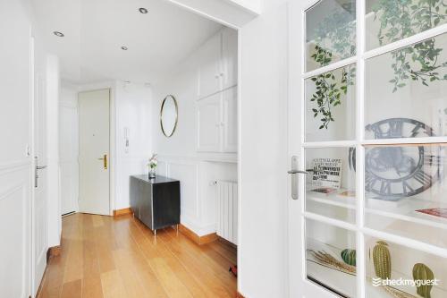 un couloir avec des murs blancs et une porte en verre dans l'établissement Fancy apartment - 2BR-6P - Gare de l'Est, à Paris