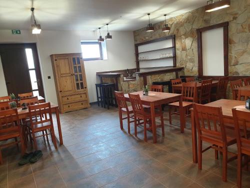 a restaurant with wooden tables and chairs in a room at Chata u Pinkasů in Jablunkov