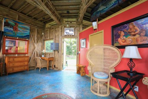a living room with red walls and a table and chairs at Kalani Oceanside Retreat in Pahoa