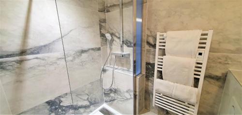 a shower with a glass door and a towel at Appart'Hôtel du Bout du Monde in Camaret-sur-Mer
