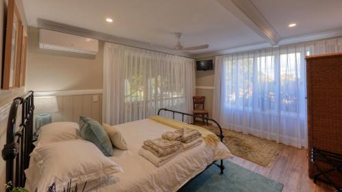 a bedroom with a bed and a large window at Mitta Glen GuestHouse in Flaxton