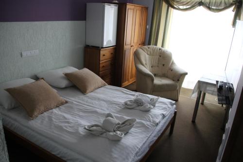 a bedroom with a bed with two flowers on it at Pensjonacik ELMI in Giżycko