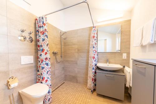 a bathroom with a shower and a toilet and a sink at Braviscasa - Ferienresidenz Bärenhof Titisee in Titisee-Neustadt