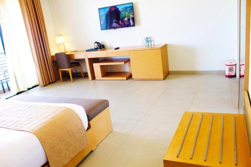 a hotel room with a bed and a desk at K Hotels Entebbe in Entebbe