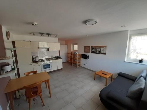 ein Wohnzimmer mit einem Sofa und einem Tisch sowie eine Küche in der Unterkunft Ferienwohnung Goltz in Thüngersheim