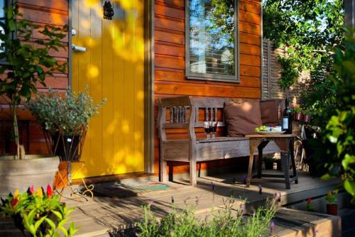 a wooden bench on the porch of a house at Piccolo Cosy Cottage with views in Hepburn
