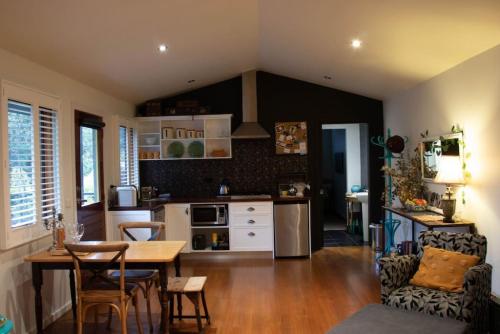 uma cozinha com mesa e cadeiras e uma sala de jantar em Piccolo Cosy Cottage with views em Hepburn