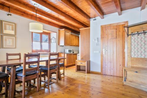 a kitchen and dining room with a table and chairs at Gessa Luxury Apartments - parking a pie de pistas Val de Ruda in Gessa