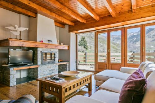 a living room with a fireplace and a tv at Gessa Luxury Apartments - parking a pie de pistas Val de Ruda in Gessa