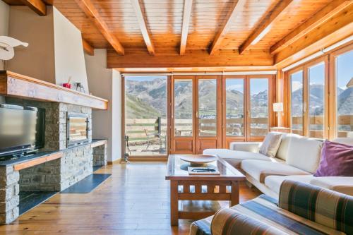 a living room with a couch and a fireplace at Gessa Luxury Apartments - parking a pie de pistas Val de Ruda in Gessa