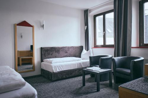 a hotel room with a bed and a mirror at Hotel Roter Hahn in Regensburg