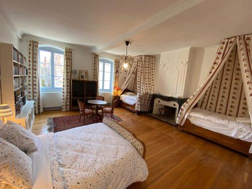 Sala de estar con 2 camas y mesa en Le p'tit relai en Montbozon