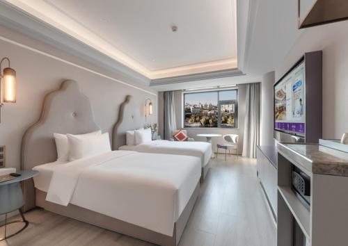 Habitación de hotel con 2 camas y TV de pantalla plana. en Mercure Lanzhou Zhengning Road, en Lanzhou