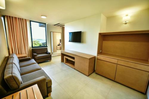 a waiting room with a couch and a flat screen tv at K Hotels Entebbe in Entebbe