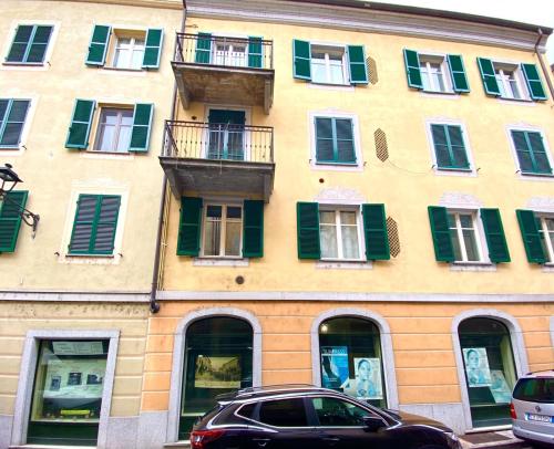 a car parked in front of a building with green shutters at HH Hermoso Housing SERRAVALLE in Serravalle Scrivia