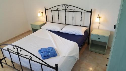 een slaapkamer met een bed met een blauwe handdoek erop bij Villa piscina 24 posti letto in Torre dell'Orso