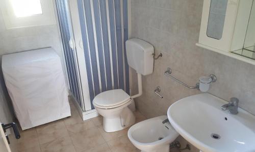 een badkamer met toilet en wastafel bij Villa piscina 24 posti letto in Torre dell'Orso