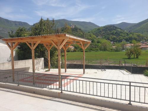 um pavilhão de madeira num parque com montanhas ao fundo em Apartmani Zlatko em Zelenika