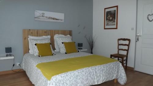 ein Schlafzimmer mit einem großen Bett und einer gelben Decke in der Unterkunft A L Ancre de la Rive in Le Faou