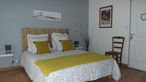 a bedroom with a large bed with a yellow blanket at A L Ancre de la Rive in Le Faou