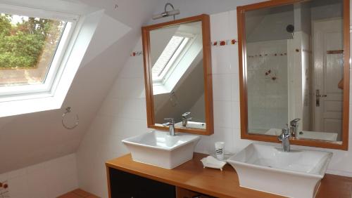 a bathroom with two sinks and a mirror at A L Ancre de la Rive in Le Faou