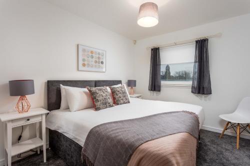 1 dormitorio con cama y ventana en Walker Suite No73 - Donnini Apartments en Kilmarnock