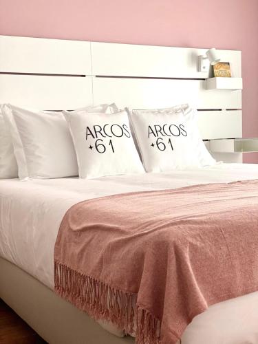 Una cama blanca con dos almohadas encima. en Arcos 61, en Tomar