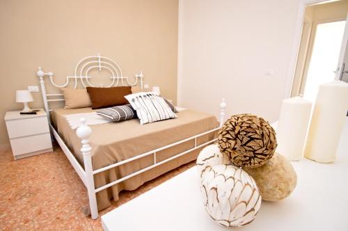 ein Schlafzimmer mit einem Bett mit einem weißen Bettrahmen in der Unterkunft Apt luminoso, spazioso con Aria condiz e bici in Viareggio