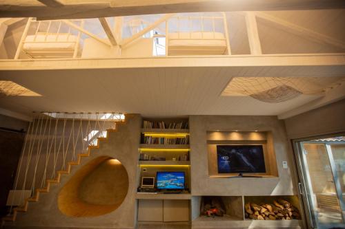 a living room with a staircase and a tv at Spa Villa Skaloma in Nafpaktos