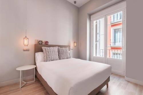 マドリードにあるArenal Suites Gran Víaのベッドルーム(白いベッド1台、窓付)