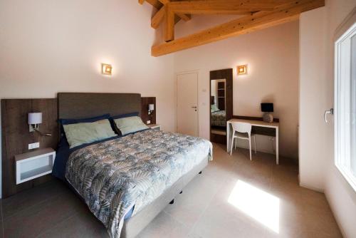 Schlafzimmer mit einem Bett, einem Tisch und einem Schreibtisch in der Unterkunft Residence Le Querce in Cordovado