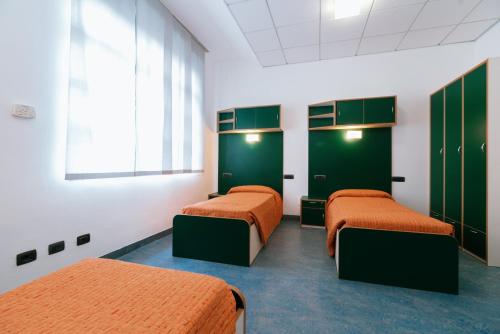 three beds in a room with green cabinets at Open011 in Turin