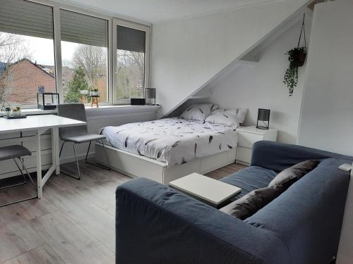 1 dormitorio con cama, escritorio y sofá en Studio 76 Groningen met gratis leenfietsen, en Groninga