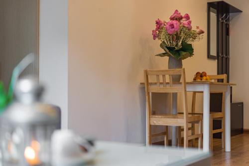 a vase of flowers sitting on a table with a chair at HNC Premier Hotel & Residences in Hanoi