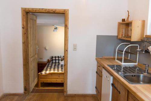 Retro Apartment Kitzbühel في كتسبويل: مطبخ مع باب يؤدي الى الغرفة