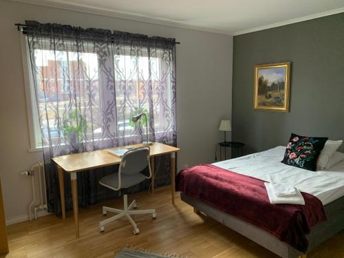 1 dormitorio con cama, escritorio y ventana en Uppsala Lägenhetshotell, en Uppsala