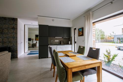 uma cozinha e sala de jantar com uma mesa de madeira e cadeiras em Pine Home em Druskininkai