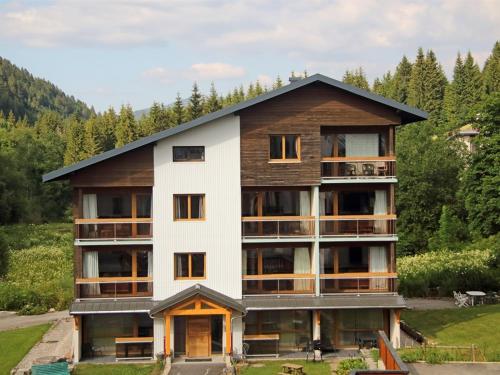 Edificio de la aominio con un blanco y madera en Les Berlicants, en Mijoux