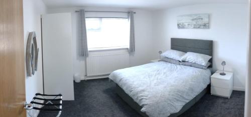 a bedroom with a large bed and a window at The Gateway Guest Apartment in Portstewart