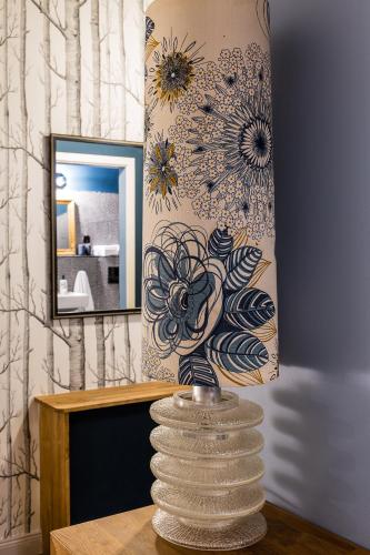 a vase sitting on a table in front of a mirror at Brilliant Apartments in Berlin