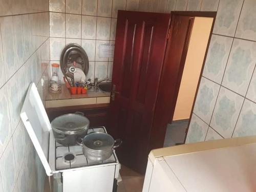 - une cuisine équipée d'une cuisinière avec deux casseroles dans l'établissement LE MILAN ( appartements et chambres meublés ), à Douala