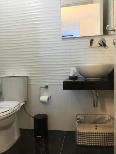Un baño con un inodoro blanco y un lavabo. en Ortigia Loft Via Malta, 22, en Siracusa
