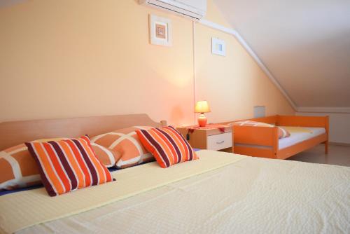 een slaapkamer met een bed met twee kussens erop bij Apartments Pine Diver in Pinezici