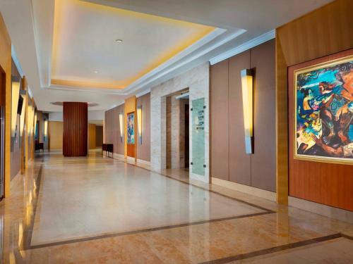 a hallway of a building with a painting on the wall at Hotel Ciputra Jakarta managed by Swiss-Belhotel International in Jakarta