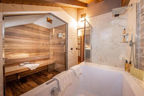 a bathroom with a white tub and a shower at Bivio Hotel Plaza in Livigno