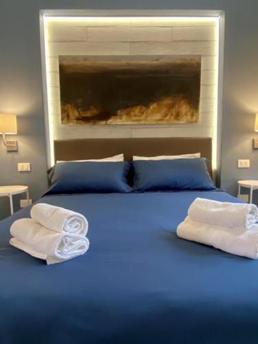 a blue bed with two towels on top of it at Beach apartments Isola d'Elba in Portoferraio
