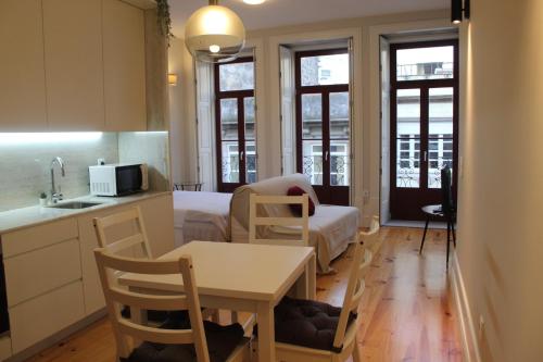 een keuken en een woonkamer met een tafel en een bank bij Oporto Coliseum Studio in Porto