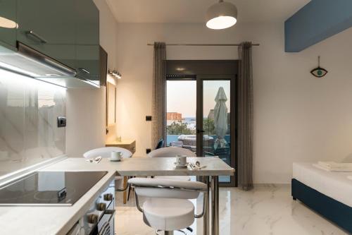 a kitchen with a table and chairs in a room at Royal Luxury Studios in Archangelos